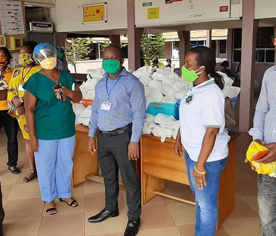 Ministry members in face masks presenting donated supplies at a hospital.